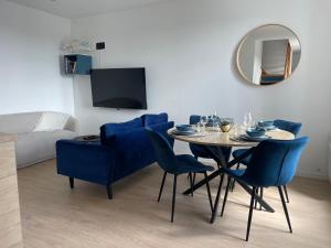 a dining room with a table and blue chairs at Duplex d Iroise rénové 2 chambres Centre Gouesnou Parking & Wifi in Gouesnou