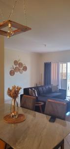 a living room with a blue couch and a table at Apart savane in São Filipe