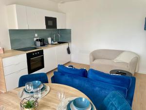 a living room with a blue couch and a table at Duplex d Iroise rénové 2 chambres Centre Gouesnou Parking & Wifi in Gouesnou