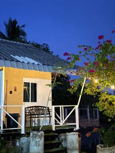 a small yellow house with a porch at night at Summer Sunshine in Songkhla