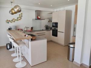 a kitchen with white cabinets and a counter top at Los Caballos Villa in Cala Galdana