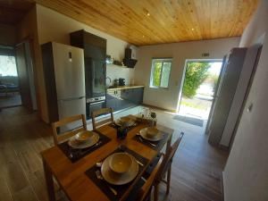 a kitchen and dining room with a wooden table and chairs at CdR Casa do Rei in Lajes das Flores