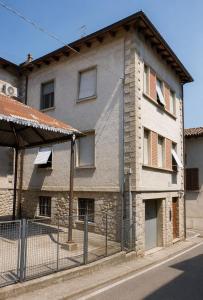 an old building with a fence in front of it at Residenza Il Castello Uno e Due in CastellʼArquato