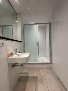 a white bathroom with a sink and a shower at Studio 21 in Hasselroth