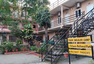 a sign in front of a building with a staircase at Tiger wildlife camp in Sauraha