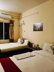 a hotel room with two beds and a window at Tiger wildlife camp in Sauraha