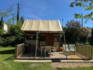 a yurt with a table and chairs on a deck at Camping Bois et Toilés in Peyraud