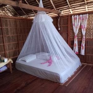 a bed in a room with a net at Batanta Explorers in Pulau Saonek-kecil