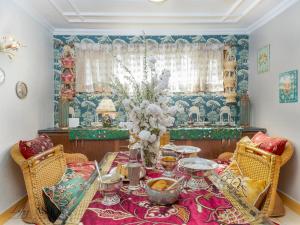 a dining room with a table with a vase of flowers at Luxury Ashok Cottage in Srinagar