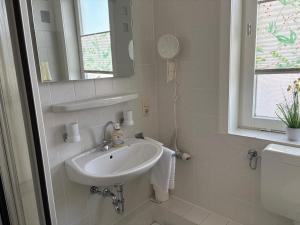 a white bathroom with a sink and a mirror at Glück Auf in Goslar +12 photos