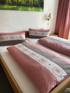 two beds in a room with pink and gray sheets at Glück Auf in Goslar