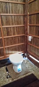 a bathroom with a toilet in a wooden wall at Batanta Explorers in Pulau Saonek-kecil