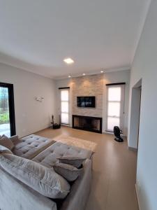 a living room with a couch and a fireplace at Casa Arara in Espirito Santo Do Pinhal
