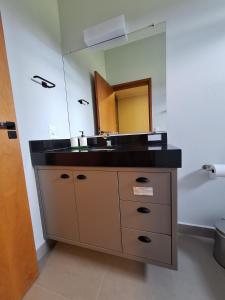 a bathroom with a sink and a mirror at Casa Arara in Espirito Santo Do Pinhal +41 photos