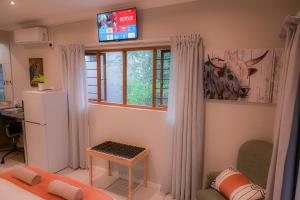 a living room with a refrigerator and a window at Son Heuwel B&B room in Nelspruit