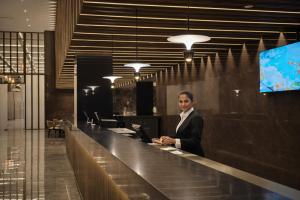 a man standing at a counter in a lobby at Colombo International Airport Hotel in Katunayaka