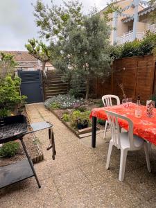 a patio with a table and chairs and a grill at Villa 4 personnes avec jardinet résidence Le Scarlett in Palavas-les-Flots