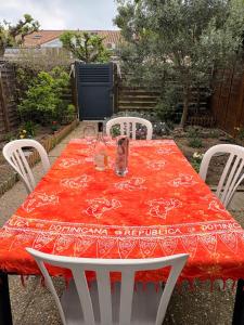 a table with two chairs and a red table cloth at Villa 4 personnes avec jardinet résidence Le Scarlett in Palavas-les-Flots