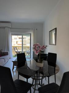 a living room with a glass table and chairs at Cerro Apartment in Carvoeiro +20 photos