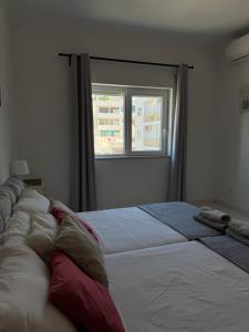a bedroom with a large bed and a window at Cerro Apartment in Carvoeiro