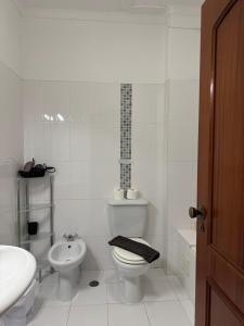 a white bathroom with a toilet and a sink at Cerro Apartment in Carvoeiro
