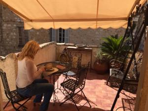a woman sitting at a table on a patio at Ma Maison in Vence