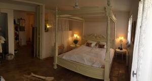 a bedroom with a white canopy bed with two tables at Ma Maison in Vence