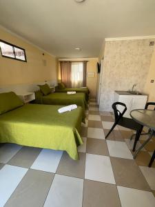 a living room with a green bed and a couch at Hotel Brasil in Antofagasta