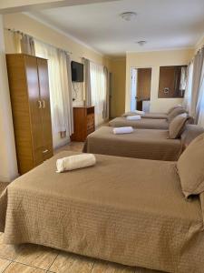 a hotel room with four beds and a television at Hotel Brasil in Antofagasta