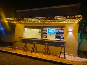 a bar with four stools in front of a building at Uhuru 50 Hotel in Kasese