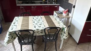 a kitchen with a table with two chairs and a table and a kitchen at Casa Alma in Cogliate +4 photos