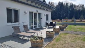 a patio with two chairs and a table and some plants at Ferienhaus zum Wunschglockerl in Schrems