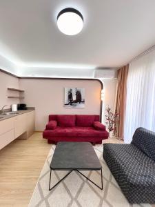 a living room with a red couch and a table at 2001 Central Stay in Peje