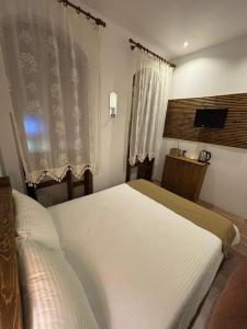 a bedroom with two beds and a television in it at Bademli Ancanoz Hotel in Dikili