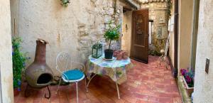 a patio with a table and chairs and a vase at Ma Maison in Vence