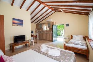 a bedroom with two beds and a living room at Potami Studios in Lefkimmi