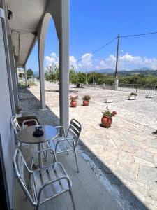 eine Terrasse mit Tisch, Stühlen und Blumen in der Unterkunft Nostos Mare in Preveza + 19 Fotos
