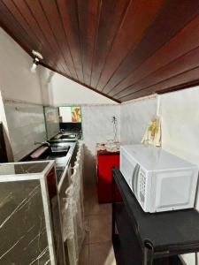 a microwave sitting on a counter in a kitchen at Chalé Rochat Maresias in Maresias