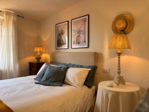 a bedroom with a bed and a table with a lamp at La Casetta Di Borgo in Lajatico