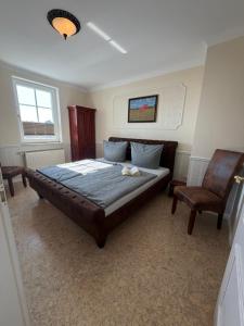a bedroom with a large bed and a chair at Appartementhaus, Villa Katharina, Sassnitz in Sassnitz