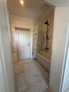 a bathroom with a tub and a walk in shower at Appartementhaus, Villa Katharina, Sassnitz in Sassnitz