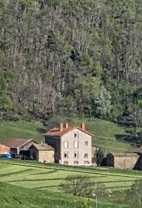 a house in a field in front of a mountain at Gerlande 2 in Bourg-Argental