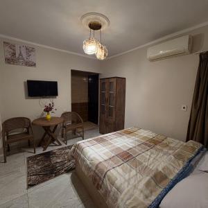 a bedroom with a bed and a table and a television at Grand pyramids view & Jacuzii in Cairo