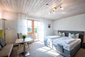 a bedroom with a bed and a couch at Hotelchen Schönblick in Gößweinstein