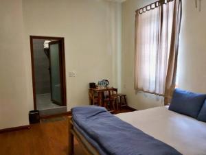 a bedroom with a bed and a mirror and a table at Bếp Thông home in Xuan An