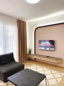 a living room with a flat screen tv on a wall at 2001 Central Stay in Peje