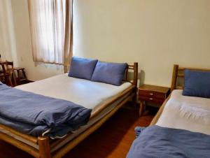 a bedroom with two beds with blue pillows on them at Bếp Thông home in Xuan An