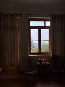 a room with two chairs and a window at Bếp Thông home in Xuan An +2 photos