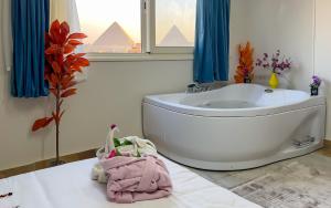 a bathroom with a bath tub and a sink at Grand pyramids view & Jacuzii in Cairo +63 photos