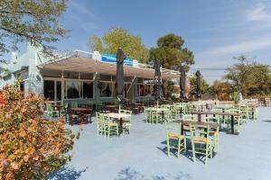 an outdoor patio with tables and chairs and umbrellas at Zen Villa Porto Molo in Ávdhira